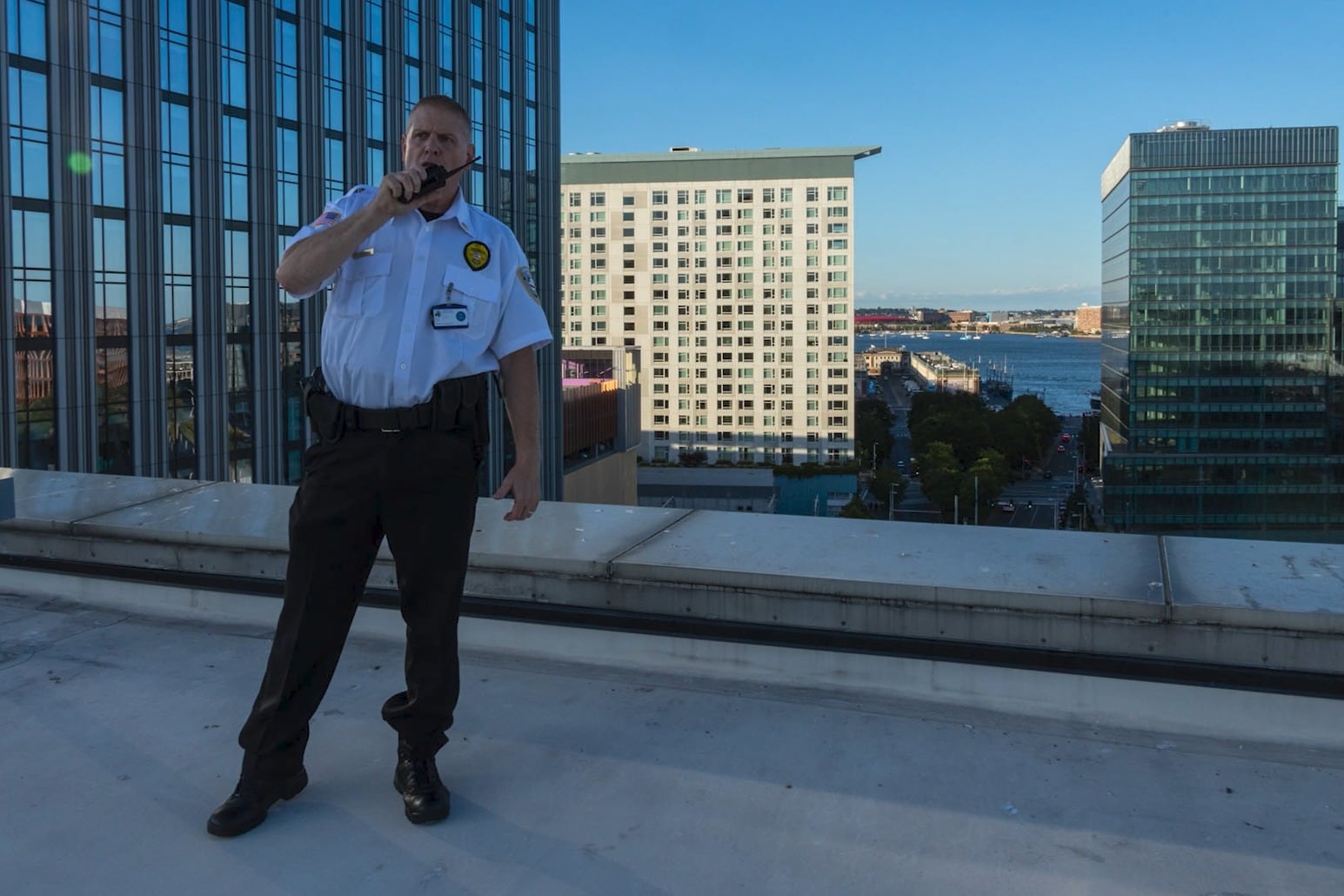 Securemedy supervisor in a white uniform directing operations by radio from a rooftop
