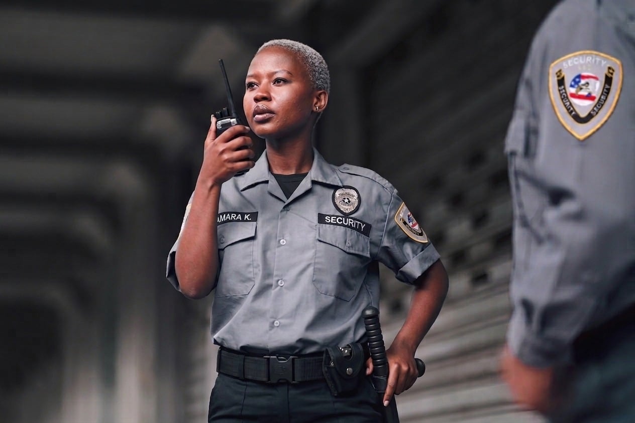 Unarmed Securemedy officer in a grey uniform communicating by radio
