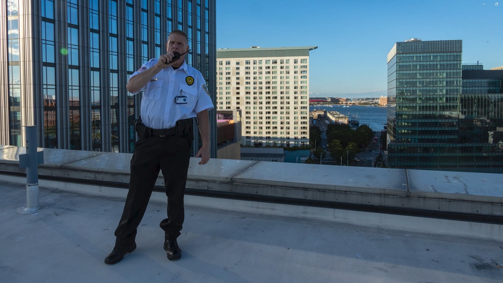 Securemedy supervisor in a white uniform directing operations by radio from a rooftop